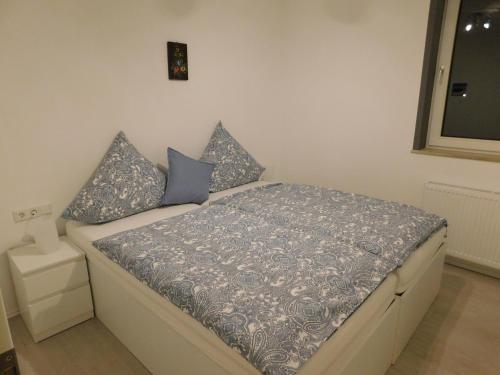 ein Schlafzimmer mit einem Bett mit blauen Kissen darauf in der Unterkunft Ferienwohnung Winterberg in Winterberg