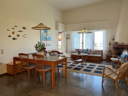 Una sala de estar con una mesa y sillas de madera. en Villa Cathrine, en Kanali