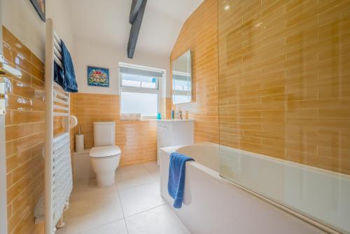 a bathroom with a tub and a toilet and a sink at Polrunny Farm Blackberry Cottage - Cornwall bliss in sight of the sea in Boscastle