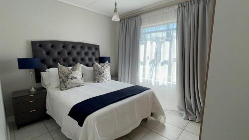 a bedroom with a large bed and a window at Greenlee Lifestyle Apartment- 2 Bedroom in Sandton