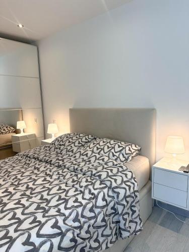 une chambre avec un lit avec une couette noire et blanche dans l'établissement Spacious, quiet apartment, à Nice