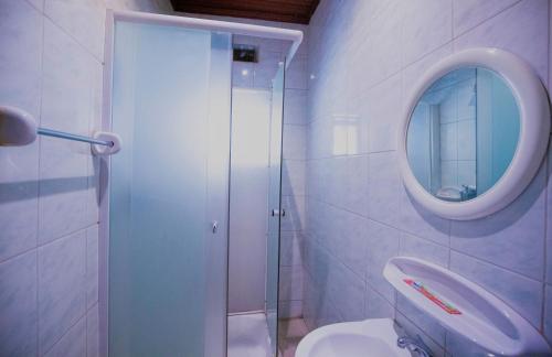 a bathroom with a sink and a mirror and a toilet at Kacyiru House Golf Course Views in Kigali