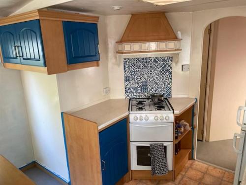 La cuisine est équipée de placards bleus et d'un four avec plaques de cuisson. dans l'établissement Mobilhome 4 personnes, à La Baule