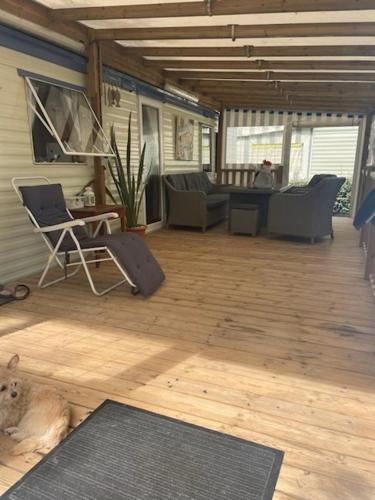 une véranda avec un canapé et une chaise dans l'établissement Mobilhome 4 personnes, à La Baule