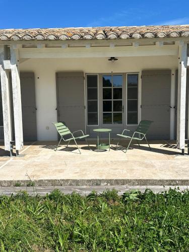 deux chaises et une table devant une maison dans l'établissement Mas du Couvin, maison d'hôtes en Camargue, à Saintes-Maries-de-la-Mer