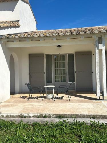 deux chaises et une table devant une maison dans l'établissement Mas du Couvin, maison d'hôtes en Camargue, à Saintes-Maries-de-la-Mer