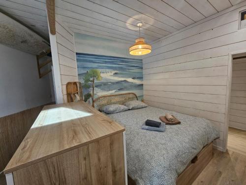 Cette chambre dispose d'un lit et d'une peinture murale. dans l'établissement Hossegor - Lac - Forêt - Couple - Piscine, à Soorts-Hossegor