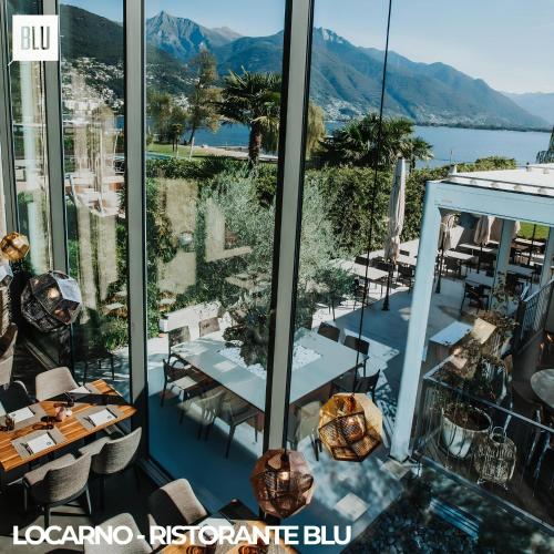 a restaurant with a view of the water and mountains at Locarno Center - Free Parking, Netflix and WiFi in Locarno