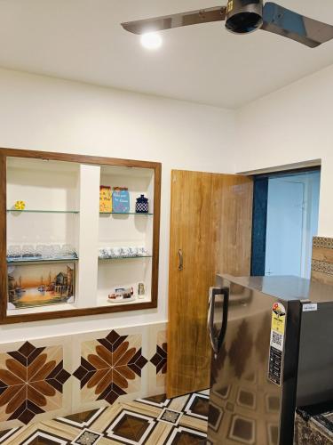 a kitchen with a refrigerator and a counter top at Zuluk Poolside Luxury Homestay with Swimming Pool in Ratnagiri