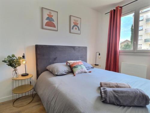 a bedroom with a bed with two pillows on it at L'artiste - centre ville in Valence