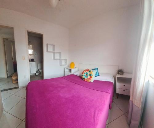 Casa Aquamarina Buzios في بوزيوس: غرفة نوم بسرير وردي في غرفة