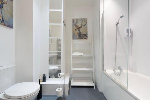 a white bathroom with a toilet and a shower at Stylish Modern Apartment by Aldgate East Station 2 in London