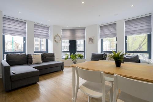 a living room with a table and a couch at Stylish Modern Apartment by Aldgate East Station 2 in London
