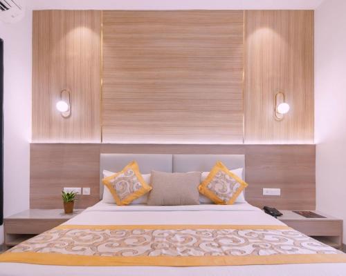 a bedroom with a large bed with yellow pillows at Hotel Star Suites By Star Group in New Delhi