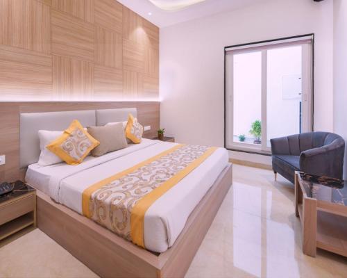 a bedroom with a large bed and a chair at Hotel Star Suites By Star Group in New Delhi