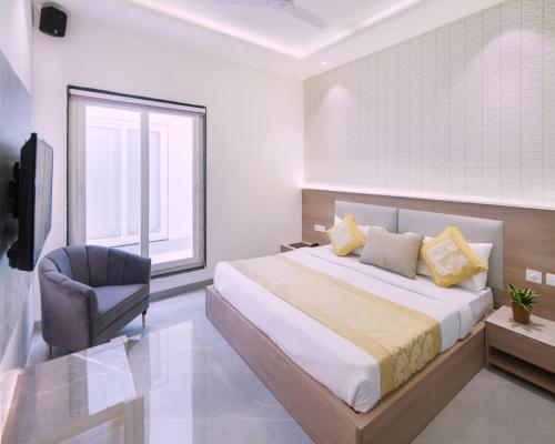 a bedroom with a bed and a chair and a window at Hotel Star Suites By Star Group in New Delhi