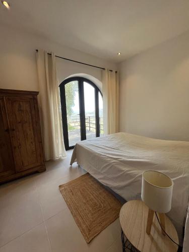 une chambre avec un lit et une grande fenêtre dans l'établissement U mulinu di gradacce, à Lavatoggio