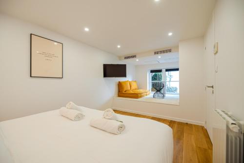 une chambre blanche avec un lit et une fenêtre dans l'établissement CIA - Spacious Duplex, Grands Boulevards, à Paris