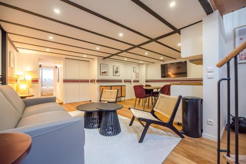 un salon avec un canapé, des chaises et une table dans l'établissement CIA - Spacious Duplex, Grands Boulevards, à Paris