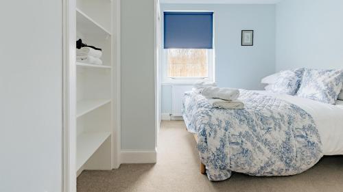 a bedroom with a bed and a chair and a window at Little Copse, Elie in Elie