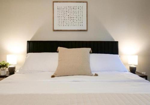 a bedroom with a white bed with a pillow on it at Modernized Historical Home in Downtown Medina with Hot Tub in Medina