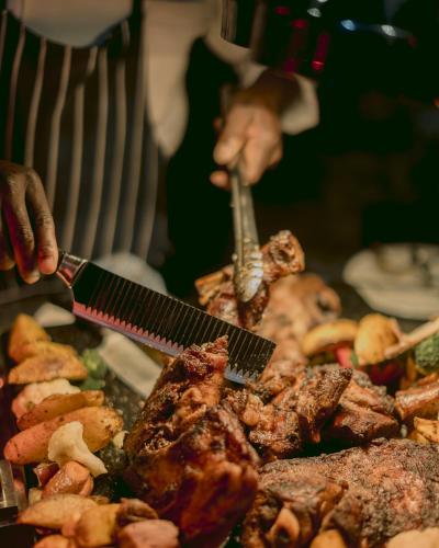 a person preparing food on a grill with a spatula at Palala Boutique Game Lodge and Spa in Tom Burke