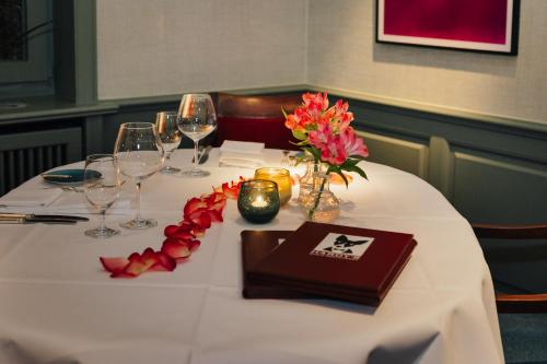 a white table with wine glasses and flowers on it at Hotel Stadt Hamburg in Westerland