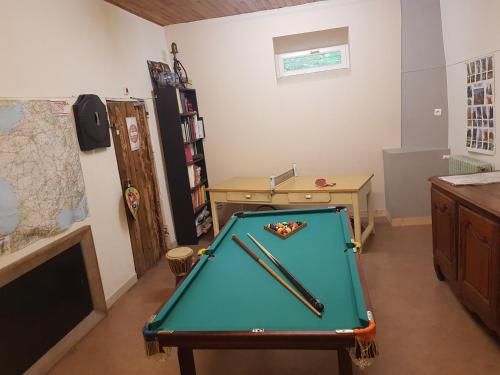 une pièce avec une table de billard avec deux battes dessus dans l'établissement Maison familiale des Gueyniers, à Jausiers