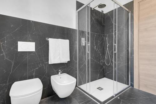 a bathroom with a white toilet and a shower at Villa Carli by Aurora - Superior Apartment in Soiano del Lago