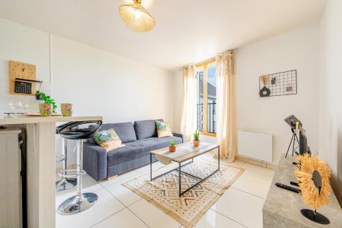 un salon avec un canapé bleu et une table dans l'établissement Urban Oasis, RER D, CDG Aéroport, Parc des Expos, à Gonesse