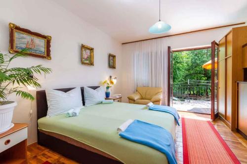 a bedroom with a large bed and a balcony at Apartment in Jadranovo 39395 in Jadranovo