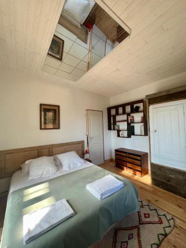 a bedroom with a large bed and a ceiling at Country Lodge in Les Épasses