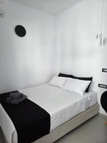 a white bedroom with a bed with white walls at Tataki Family Hotel in Fira