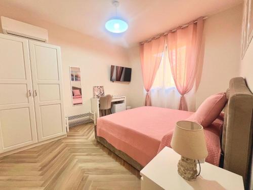 a small bedroom with a pink bed and a desk at La Casa di Nina in Castelnuovo Cilento