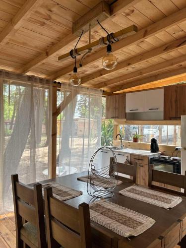 a kitchen with a wooden ceiling and a table with chairs at Нереида in Sozopol