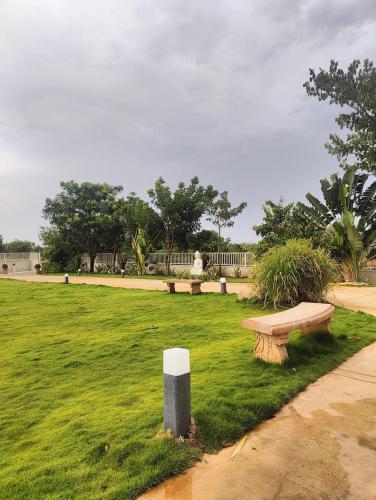 a park with benches in a grassy field at Riniya in Venkatāpur