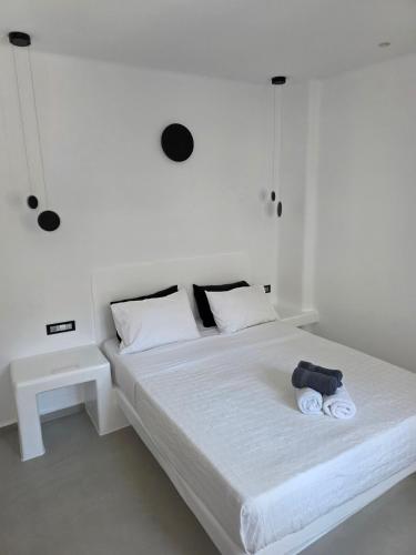 a white bed with a stuffed animal on it at Tataki Family Hotel in Fira