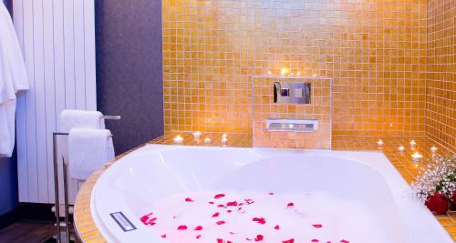 a bathroom with a tub with red hearts on the floor at PLAZA INN stays design Dortmund in Dortmund
