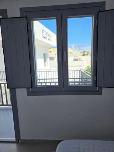 a window in a room with a view of a building at Tataki Family Hotel in Fira