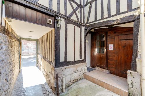 an entrance to an old building with a wooden door at Appartement Cosy Tout confort Elbeuf in Elbeuf