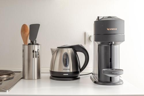 a coffeemaker and a coffee maker on a counter at Appartement Cosy Tout confort Elbeuf in Elbeuf