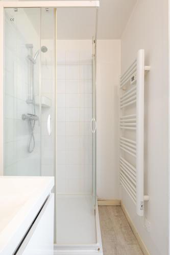 a white bathroom with a shower and a sink at Appartement Cosy Tout confort Elbeuf in Elbeuf