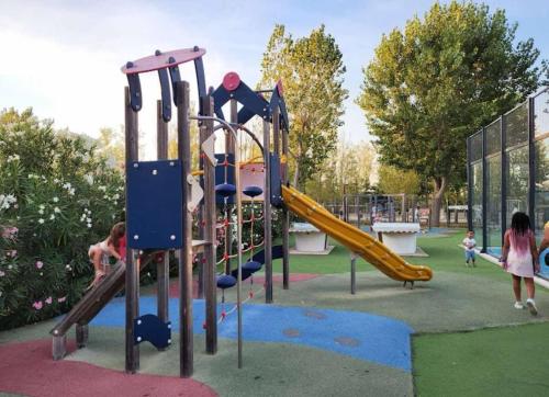 une aire de jeux avec un toboggan dans un parc dans l'établissement Mobil Home - Camping siblu les sables du midi - Valras Plage, à Sérignan