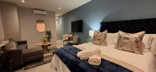 a bedroom with a large bed and a living room at Ocean Club Zimbali Lakes D16 in Ballito