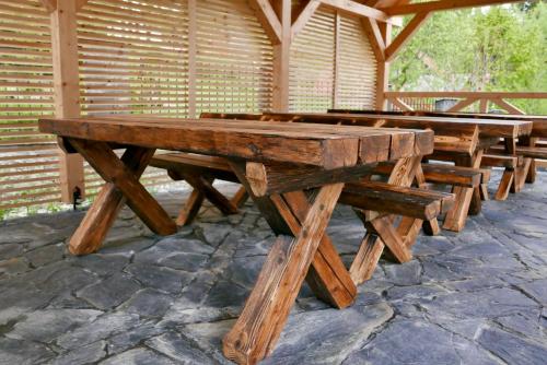 a row of wooden picnic tables in a pavilion at Dzika Dziura z jacuzzi in Zawoja