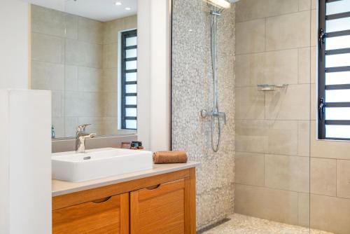 a bathroom with a sink and a shower at Villa Secret Garden by IHR - Villa privée 2 chambres avec piscine in Rivière Noire