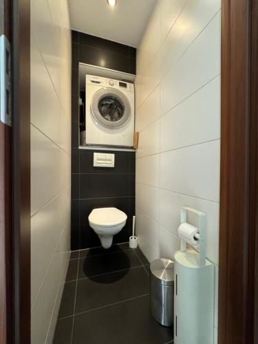 Un baño con inodoro y lavadora. en Apartament Sandra, en Kielce