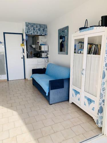 - un salon avec un canapé bleu et une porte dans l'établissement Studio Kamarina, à Sanary-sur-Mer
