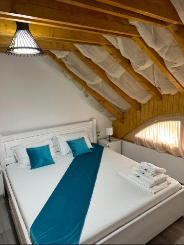 a bedroom with a white bed with blue pillows at Complex Andris in Murighiol