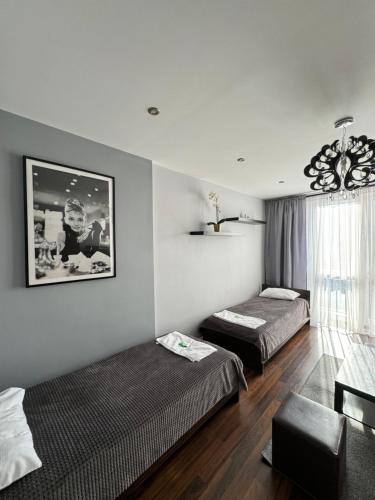 una habitación de hotel con dos camas y un sofá en Apartament Sandra, en Kielce